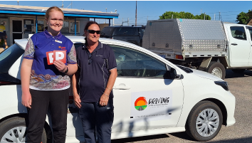 Emilie from Carnarvon in front of a car after passing her driving test.