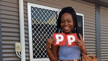 Joanita smiling and holding her P Plates.