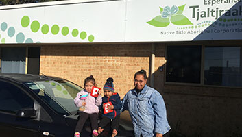 Roechelle and her two children in front of a car, holding her new P Plates.