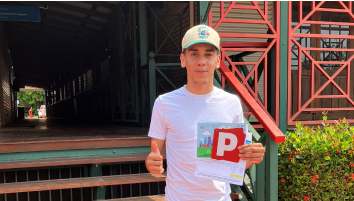 Steven from Broome, holding his P Plates and giving a thumbs up after passing his driving test.